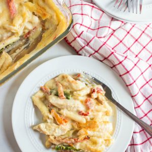 Cheesy Chicken Penne served on a plat with a red and white napkin