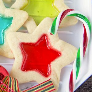 Stained glass cookies are a delicious, beautiful, and easy to make holiday cookie. Soft, buttery cookie dough, rolled out and cut into holiday shapes, then filled with melted candies so they look like stained glass.