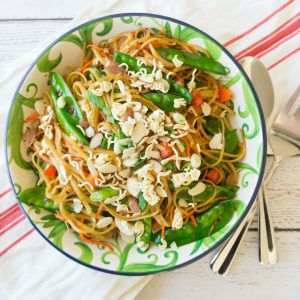 Change up your traditional summer pasta salad for this Spicy Asian Pasta Salad, it will be the hit of all your summer parties! This pasta salad is full of fresh vegetables and topped with some crushed ramen noodles and slivered almonds. #pastasalad