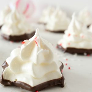 close up image of meringue cookies dipped into melted chocolate