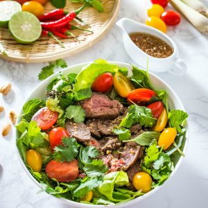 thai beef salad in a white bowl